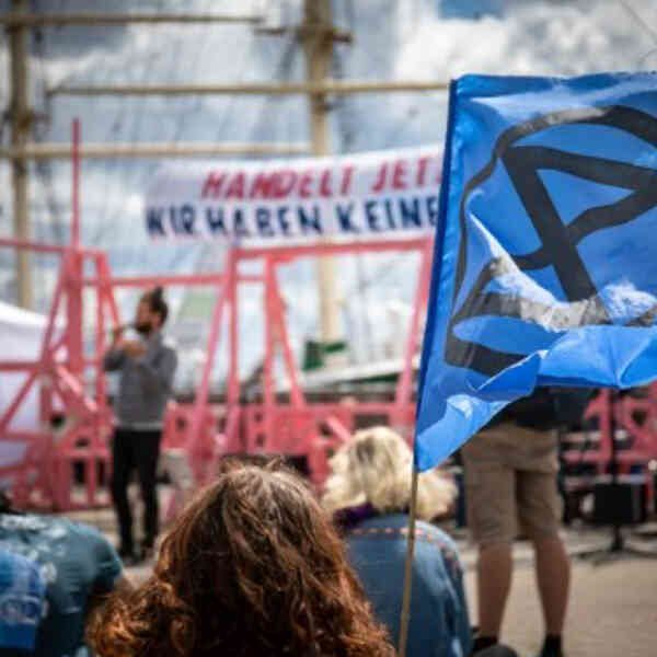 Eine blaue Fahne mit Schwarzer Stilisierter Erde und  Sanduhr drinnen (XR Logo)