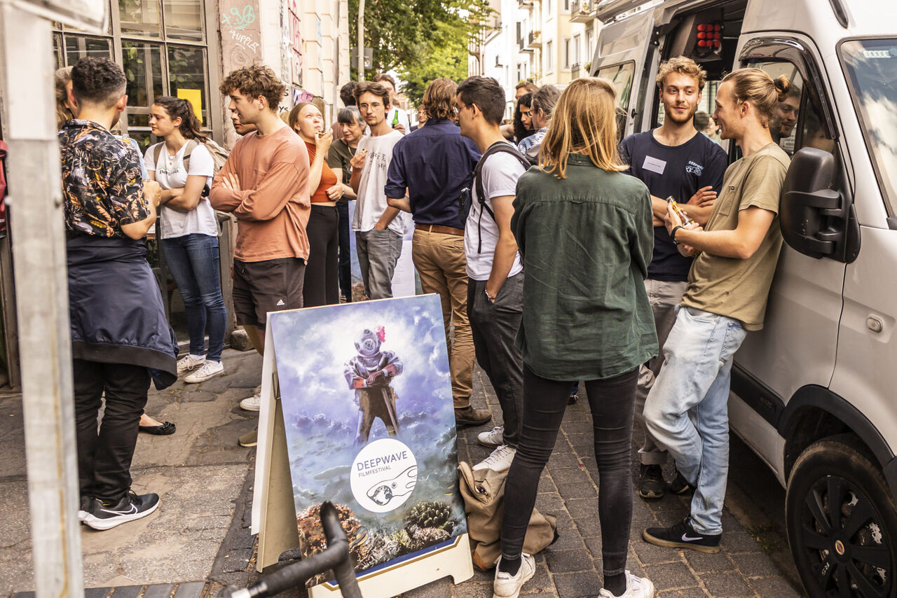 Besucher:innen des Filfestivals stehen vor dem Lichtmeß Kino auf der Straße und unterhalten sich.
